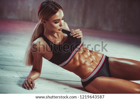 Young sexy slim woman showing abdominal muscles