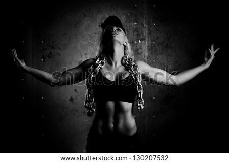 Young sports woman with heavy chain. Black and white.