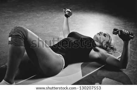Young sports woman dumbbells exercises. Black and white.
