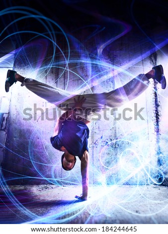 Young man break dance on wall background. With light effects.