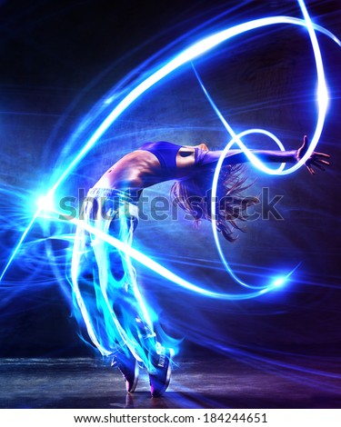 Young woman dancer. With light effects.