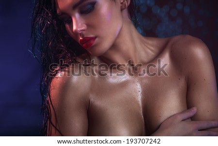 Young sexy wet woman portrait. Focus on chest.