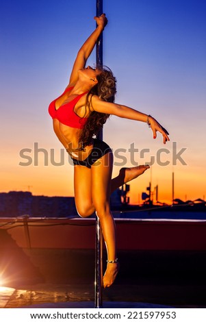 Young sexy pole dance woman on urban background.