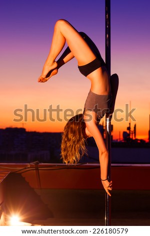 Young pole dance woman on urban background.