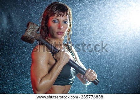 Young sexy sports woman with heavy hammer water studio portrait.