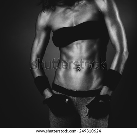 Young sexy strong muscular woman body. Black and white film style colors.