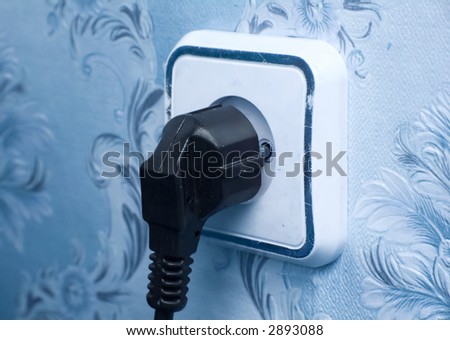 Two-pin plug in a socket. Photo specialy with blue tint.