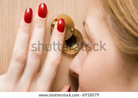 Woman looking into spy hole closeup.