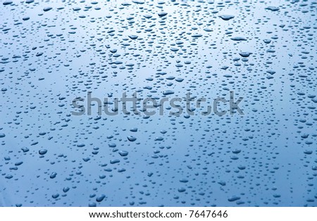 Water drops on car hood. Blue tint.