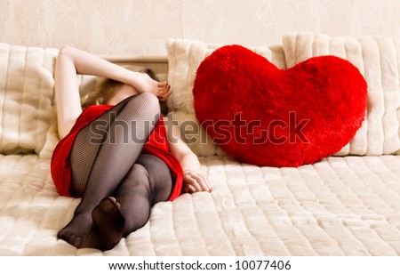 Young Woman Resting On A Bed And Heart Shaped Pillow. Concept ...