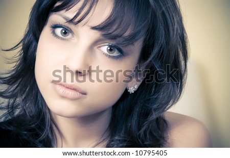 Young brunette woman concept portrait. Non-standard soft yellow and blue tinting.
