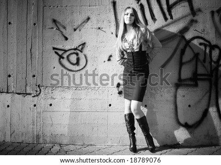 Young woman on graffiti wall background. Black and white.
