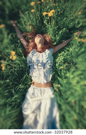 Young woman lying on grass. Top wide angle view. Selective focus effect.