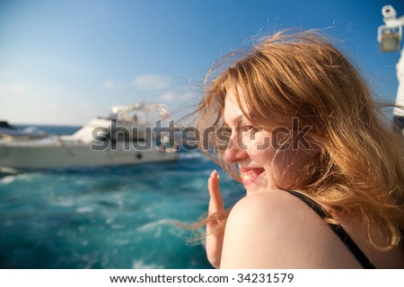 Young woman waving hand when leaving tropical island.