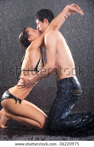 Young couple kissing. Water studio photo.