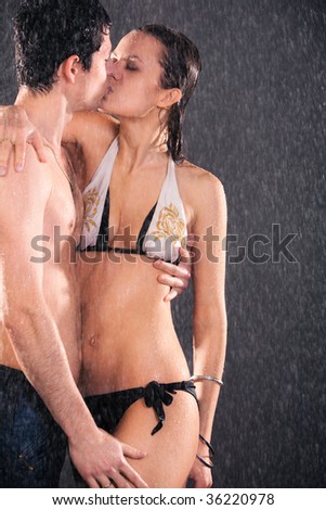 Young couple kissing. Water studio photo.