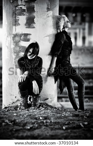 Two goth women at the column. Contrast black and white colors.