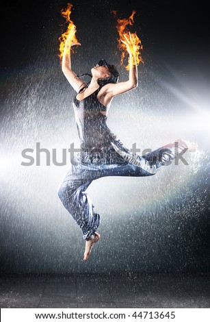 Young woman modern dance. Water studio photo and fire effect.
