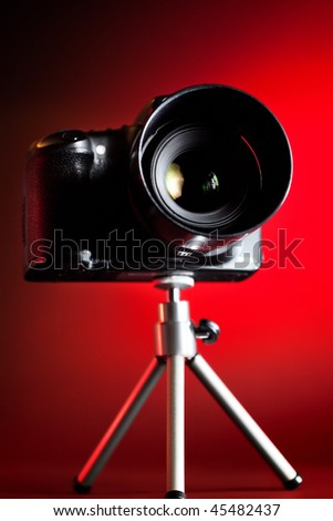 Professional DSLR camera on red background.