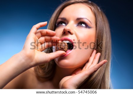 Young woman eating sweet portrait. Focus on sweet.