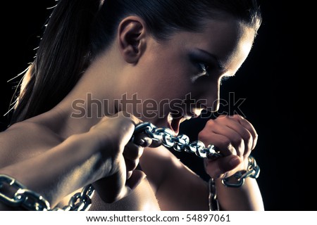 Young fashion woman breaking metallic chain.