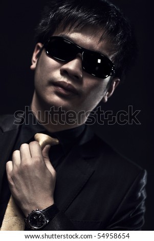 Cool japanese man in sunglasses portrait. Dark colors.