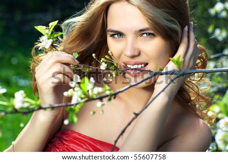 Young woman biting small branch outdoors portrait.