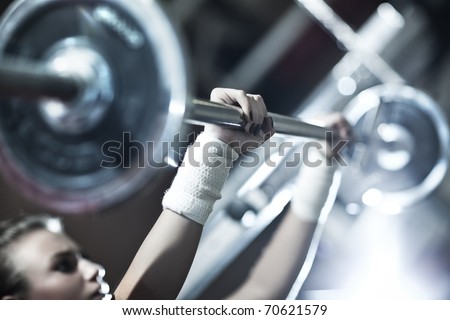 Young woman weight training. Focus on hand.