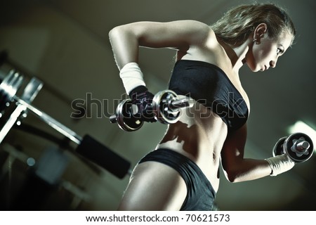 Young woman weight training. Camera angle view.