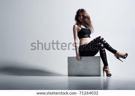 Young woman fashion. On wall background.