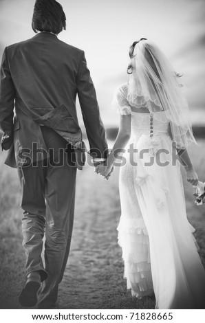 stock photo Young wedding couple walking on field Retro style black and 
