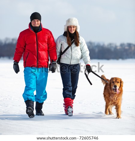 Young couple walking with dog.