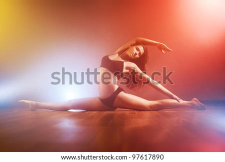 Young slim woman stretching. With fog effect.