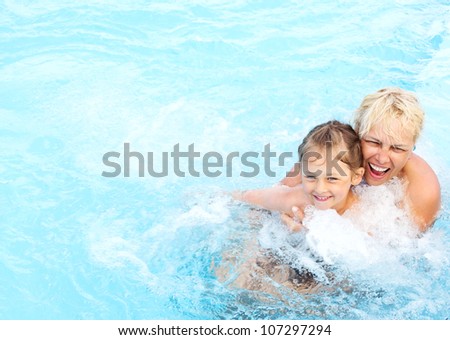 middle-aged woman and a little girl swimming in the pool with hydro-massage