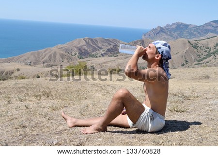 A young man drinking water, in summer, hot day