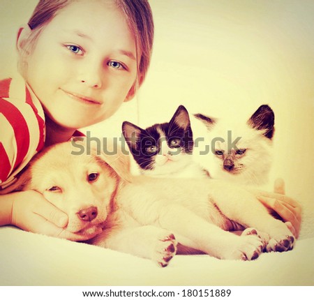 child hugging a puppy and kitten