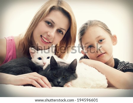 girls hugging cats