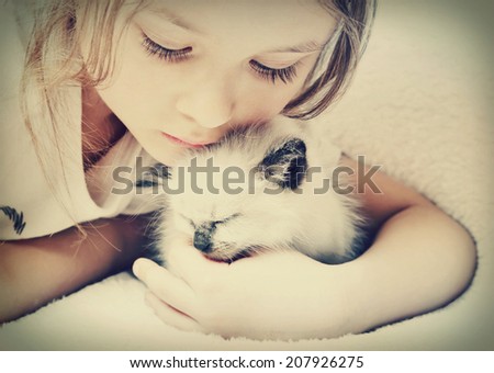 little girl hugging kitten