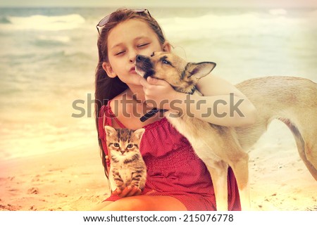 child and dog and cat on the beach