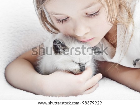 little cute girl affectionately hugging  kitten