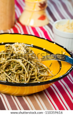 pesto pasta cooked and served with a yellow round plate