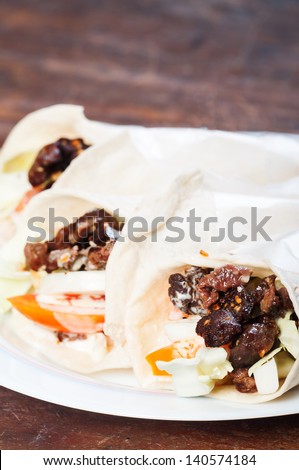 beef with tomatoes lettuce and onions drizzled with garlic sour cream wrapped in pita bread/beef shawarma