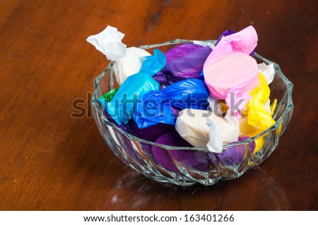 colorful wrapped polvoron/milk candies on a clear bowl