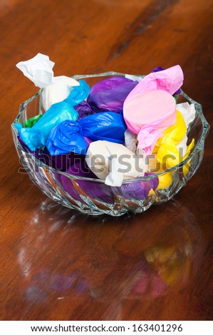 colorful wrapped polvoron/milk candies on a clear bowl