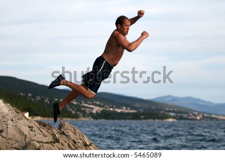 Leaping Into A New Future  A young man jumps from a cliff into the sea!