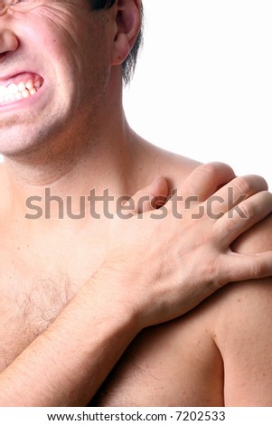 Pain In The Shoulder A young man holds his shoulder in severe pain. Isolated over white!