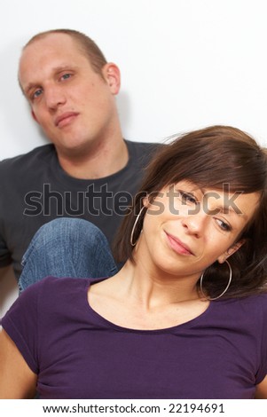 A young couple is thinking about their future. The focus is on the woman in front.