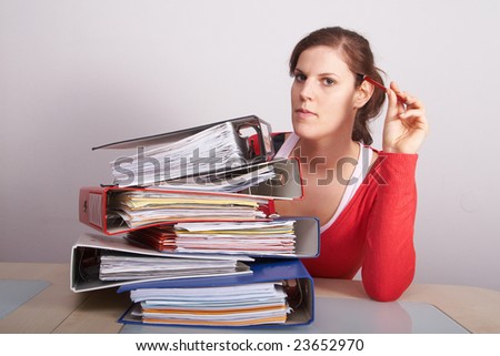 Young woman working on a huge amount of papers.