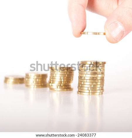 A hand is stacking up coins. The last coin is dropped. The coins are mirrored. Isolated over white. Ideal Businesshot.