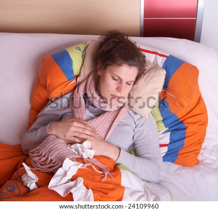 Young sick woman lying in bed. She is staying home from work. She is sleeping.